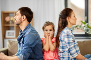 family problem, divorce and people concept - unhappy father, mother and sad little daughter at home